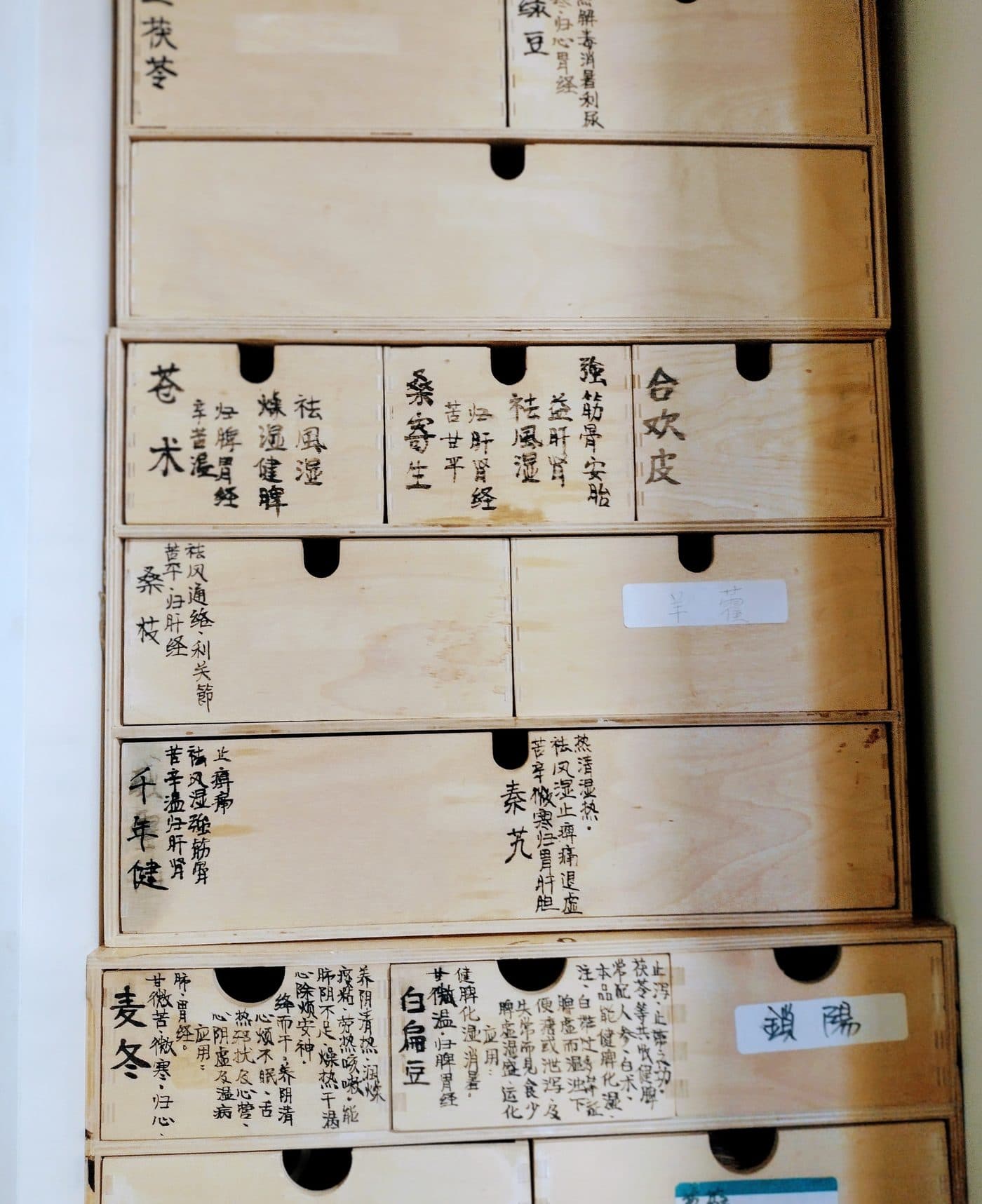A traditional Chinese herb cabinet at the clinic, its drawers labelled by hand.